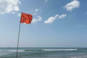 rojo bandera en playa en mar o Oceano como un símbolo de peligro. el mar estado es considerado peligroso y nadando es prohibido. foto