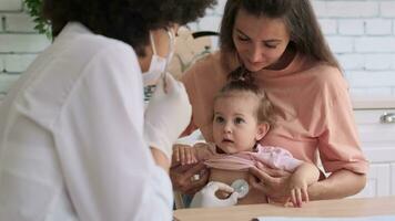 afro americano donna medico ascolta per bambino respirazione durante verifica a casa. famiglia medico, paziente sostegno, Aiuto a casa, cura per il malato. video