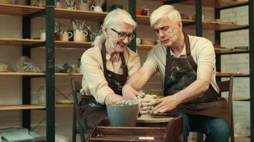 Pottery Art, Senior Couple, Mutual Support, Elderly Age.Seniors in love, a woman and a man are engaged in pottery. The senora smears the senor's face with clay. video