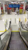 Shopping center escalator. 5.10.23 Mississauga Canada. Escalator for shoppers. A shopping cart stands with purchases. The concept of safety and convenience for customers. Carts escalator. video