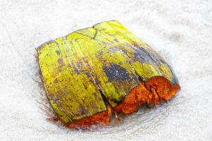 Old fallen coconut lies on the beach and rots away. photo