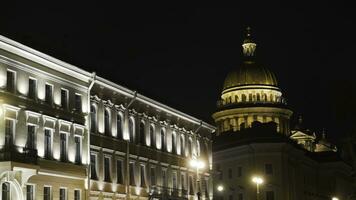 Historical building with lighting on background of Cathedral at night. Action. Beautiful old architecture glows at night. Dome of Cathedral is brightly lit in night photo