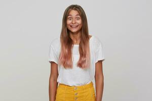 Suprised young pretty blonde woman with casual hairstyle rounding her brown eyes and raising amazedly eyebrows while looking at camera, isolated over white background photo