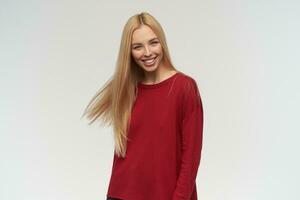 Portrait of attractive, adult girl with blond long hair. Wearing red sweater. People and emotion concept. Watching at the camera, isolated over white background photo