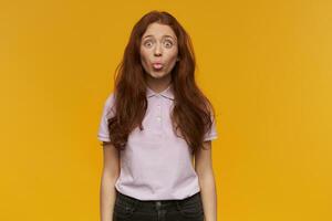 Ginger girl standing over yellow background photo