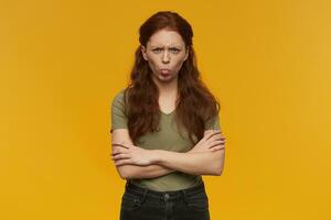 Ginger girl standing over yellow background photo