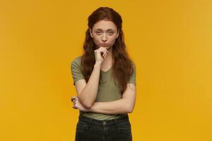 Ginger girl standing over yellow background photo