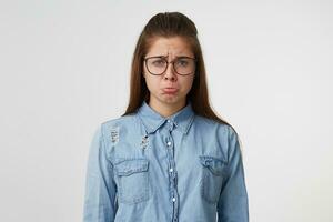 un niña es trastornado como un niño es acerca de a llorar, convertido fuera su inferior labios, barbilla metido en, ceñudo, triste trastornado aislado en blanco antecedentes foto