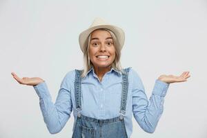 Guilty and confused young girl shrugging shoulders, making helpless gesture with hands, having Oops expression on her face. Feeling sorry for doing something wrong,over white background photo