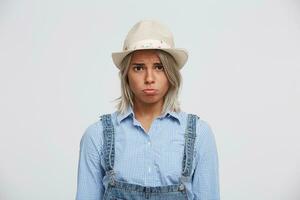 Offended young girl upset that did not receive a gift, received an unpleasant comment, bad review, low rating, looks directly into the camera, dressed in ordinary clothes, on a white background. photo