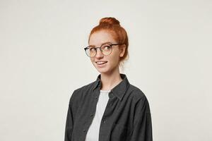 Headshot of an attractive charming female with red hair, dreamily looks away, imagine something pleasant, nicely smiling, over white studio background photo