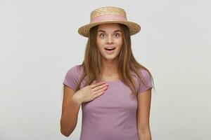 Portrait of beautiful female with surprised expression, looks with bugged eyes and keeps mouth open, indicates at herself, isolated over white background. Human reaction and emotions concept photo