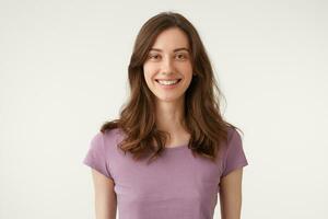 alegremente extensamente sonriente bonito mujer mirando cámara directamente, vestido en Violeta camiseta, aislado en un blanco antecedentes. foto