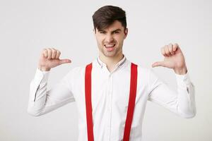 Yeah, I am a winner Self-confident young guy did something significant, wants to receive honor and respect. Looks happy pointing on himself with thumbs, feels like a leader, successful man photo