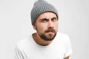 Studio photo of a young man, as if looking into the peephole with interest, shrill, meticulously, waiting until they open, the neighbor from below came complaining about the noise, white background