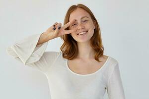 young positive female shows v sign into camera photo