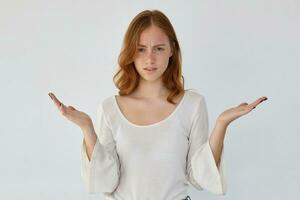 ginger female raised her hands with confused, puzzled facial expression photo