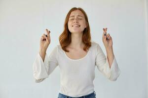 young ginger female cross fingers and praying photo