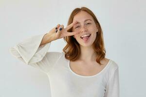 young positive female shows v sign into camera photo