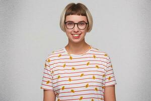 Portrait of happy beautiful young woman wears striped t shirt and glasses smiling and looks directly in camera isolated over white background photo