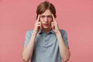 retrato joven hombre pensamiento, molesto difícil a recuerda alguna cosa mirando enfocado, dedos en templos aislado rosado antecedentes. negativo emoción facial expresiones Corto plazo memoria pérdida foto