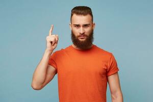 Serious man came up with a important great idea Guy is inspired isolated on bright blue background.Indoor shot of pensive bearded male tries to concentrate, has thoughtful expression. photo