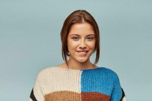 Studio photo of a beautiful girl looking playful flirting. Pretty woman with good make-up isolated on blue background