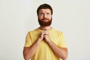 Portrait of peaceful brutal young man with beard wears yellow t shirt feels photo