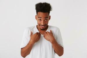 retrato de sonriente confuso africano americano joven hombre con afro peinado foto