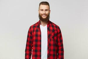 Smiling excited funny young attractive bearded man, dressed in checkered shirt, has happy joyful positive face expression, smiling, isolated on white background photo