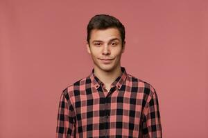 un hombre en un rosado y negro a cuadros camisa foto