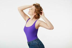 Young happy fabulous short-haired girl, wearing a purple jersey, smiling broadly, shows natural beauty,straightens hair with his hands, smiling broadly, enjoy the life, isolated over white background. photo