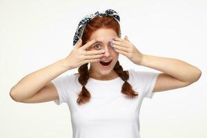 Indoor portrait of young ginger female posing over white background flirts with new boyfriend photo