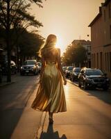 ai generado hermosa joven mujer en un largo amarillo vestir caminando en el calle a puesta de sol. ai generativo foto