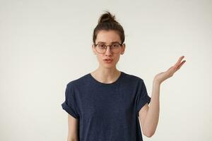 Daughter hates when parents scolding. Bothered and annoyed european female student keps one hand up standing over white background, being bored and fed up of nonsense talks photo