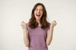 Happy girl celebrating victory. Young woman happy smiling raising her fists up, depicts a gesture of success, breaking through to achieve a goal, isolated on white background photo