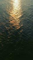 Aerial view of the blue surface of the sea or ocean at sunset video