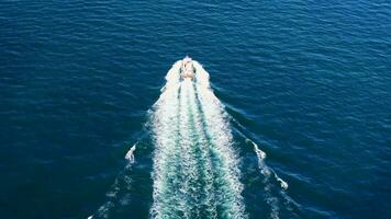 aereo Visualizza di veloce barca su un' in profondità blu mare con bianca onde video