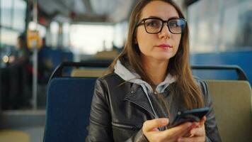 público transporte. mujer en tranvía utilizando teléfono inteligente, lento movimiento video