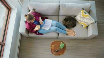 Overhead view of woman is reading a book and drinking a coffee video