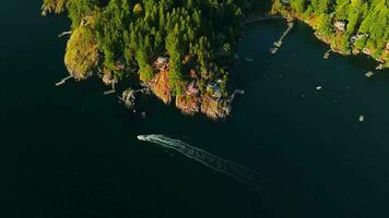 Top down view of motor boat sails around the coast of the island video