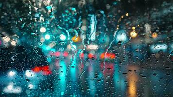 lichten van de avond stad en voorbijgaan auto's door een nat regenachtig venster. video