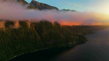 aérien vue de le côte et montagnes dans le brouillard pendant étourdissant le coucher du soleil. video