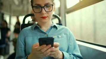 Öffentlichkeit Transport. Frau im Brille im Straßenbahn mit Smartphone. video