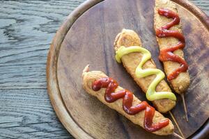 Corn dogs on the wooden board photo