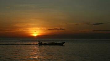 Silhouette of a Boat on the Sea at Sunset photo