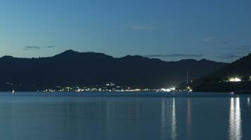 noche ver de el playa con ciudad luces en el antecedentes foto