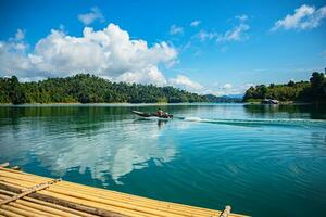 Khao Sok National Park, Surat Thani, Landscape Mountains with longtail boat for travelers, Cheow Lan lake, Ratchaphapha dam, Travel nature in Thailand, Asia summer vacation travel trip. photo