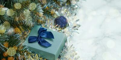 Christmas composition with Christmas tree branches in blue and silver balls and blue gift box photo