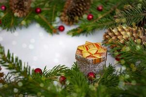 Christmas holiday picture in red and green colors, gift box, cones, green spruce branches, red balls, berries. Background for New Year and Christmas. photo